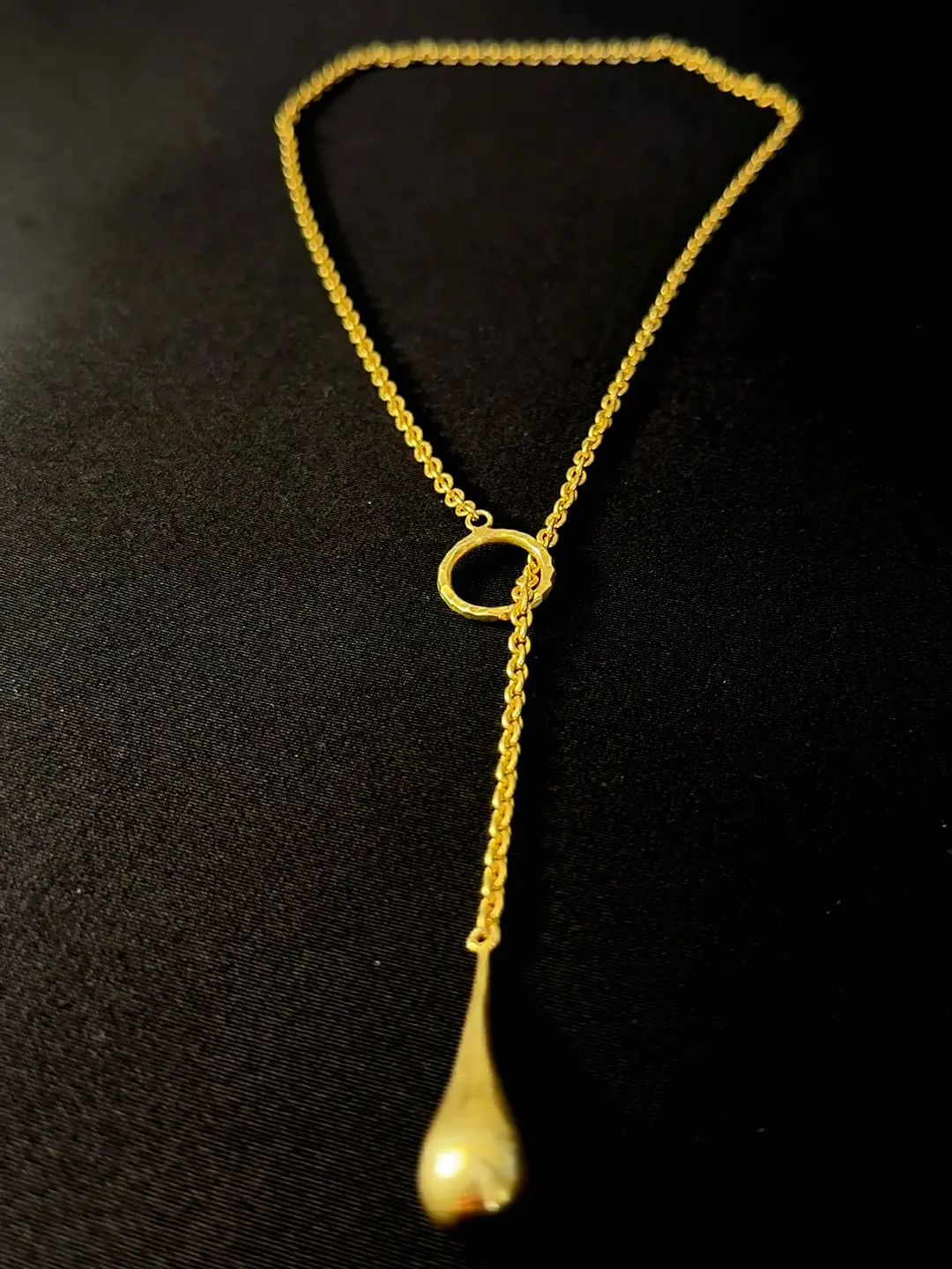 The full Amrit lariat on black, ring and drop extended