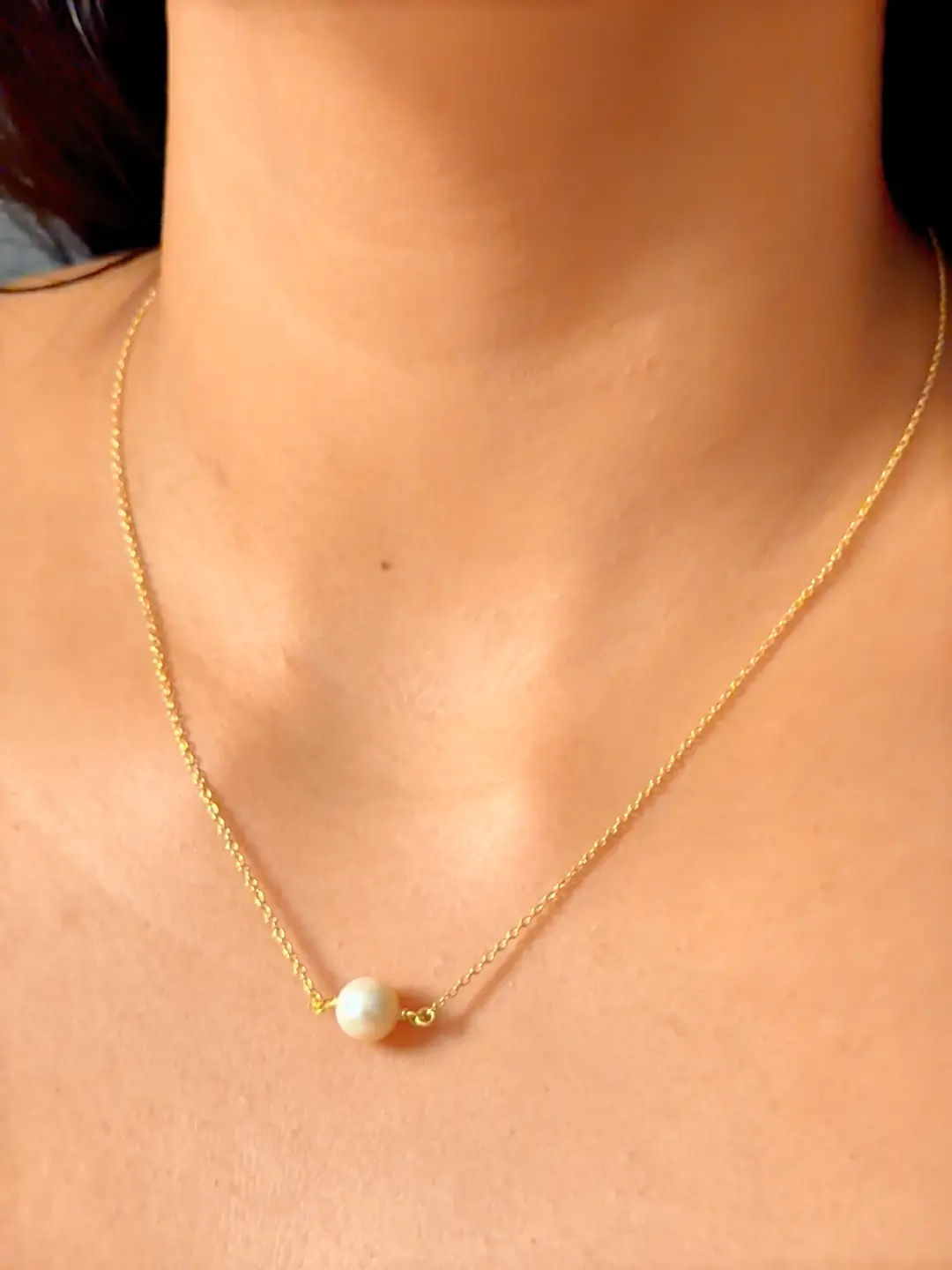 Bindu single pearl pendant necklace worn at the collarbone on a fine gold chain