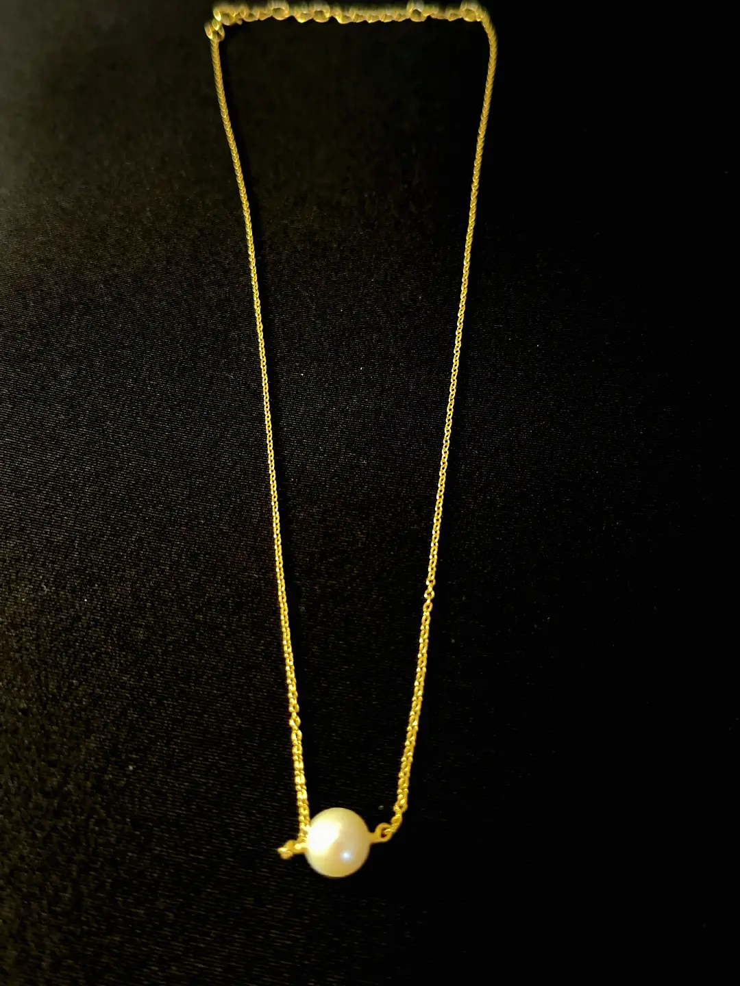 The full Bindu necklace laid out, one freshwater pearl on a fine gold chain