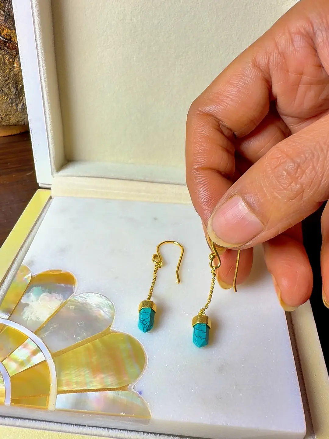 Boond earrings held in the hand, showing how small and light they are