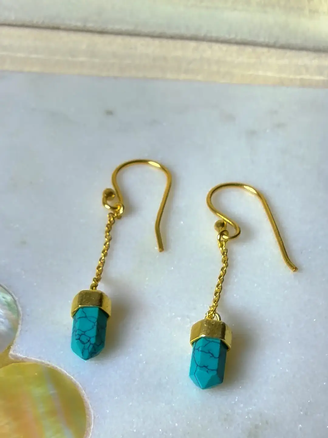 Close view of the gold-capped turquoise point and fine chain