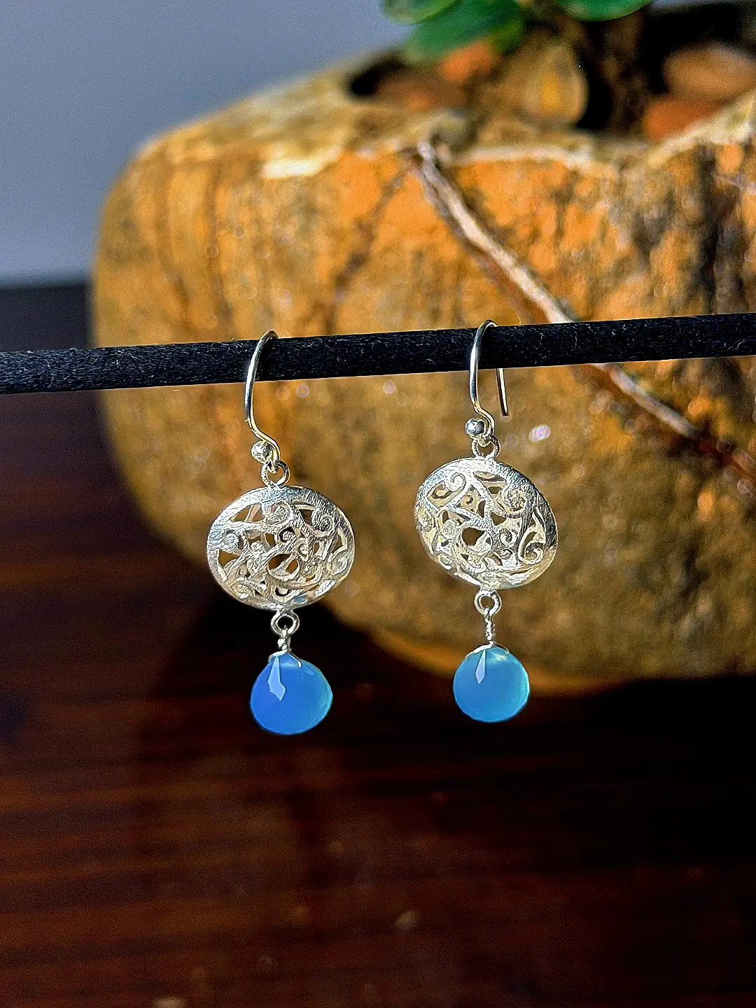 Jheel earrings hanging, showing the drop of the blue chalcedony briolettes