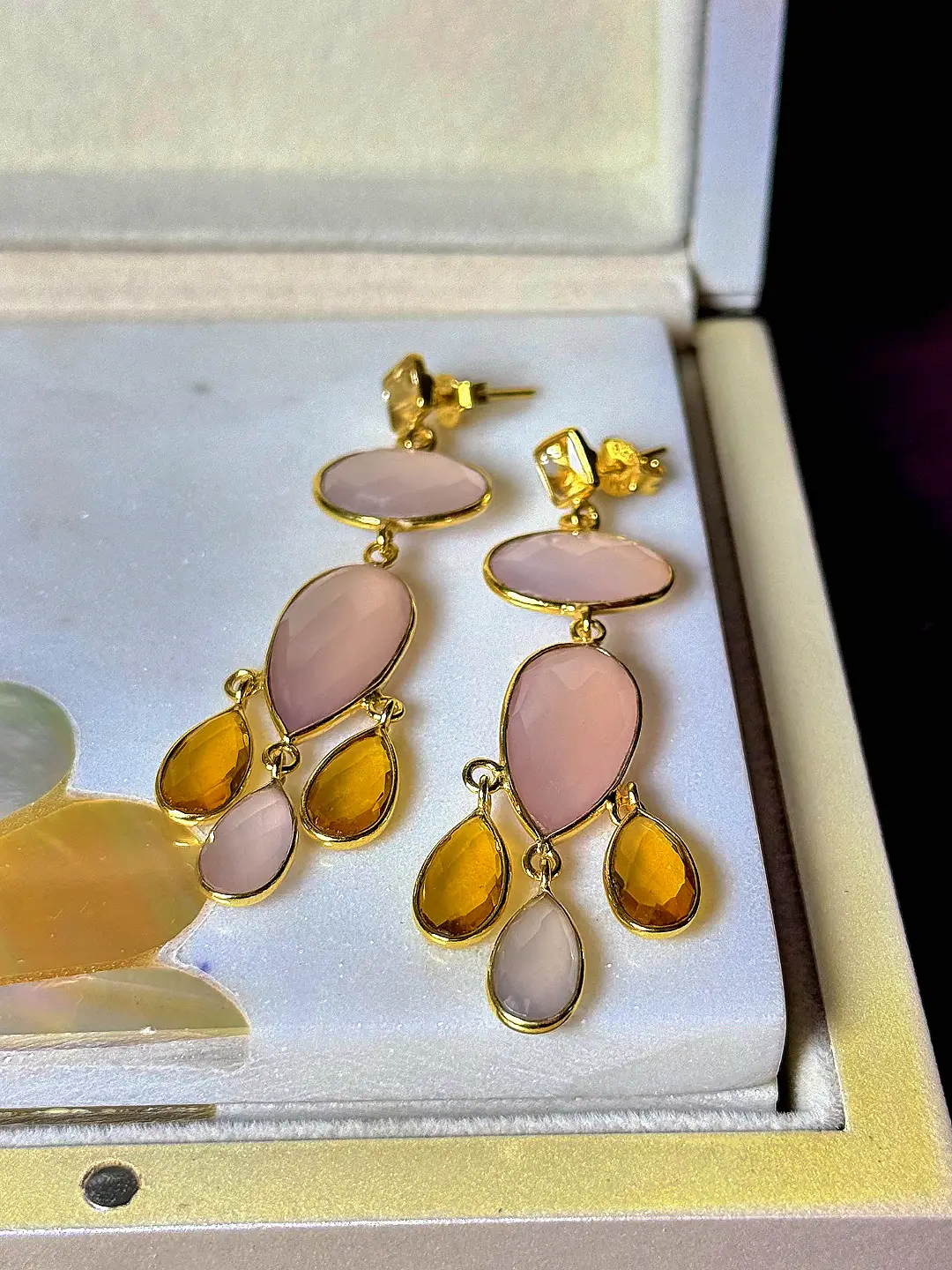 Jhumar chandelier earrings angled to show the linked rose quartz and citrine tiers