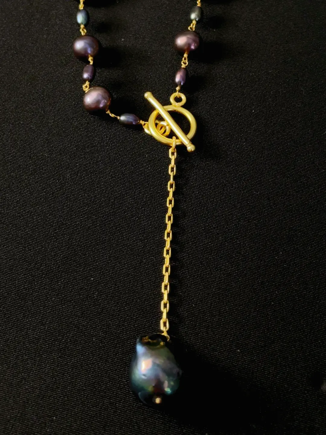 Close view of the Nisha front toggle and the baroque black pearl on its chain drop