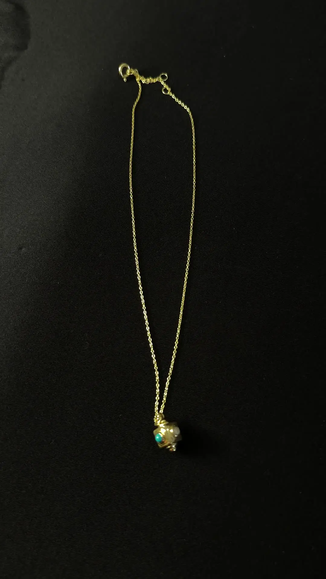 The Pasa cube turning on its gold chain