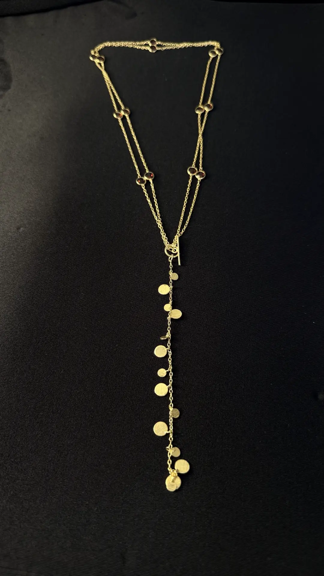Payal lariat — garnets along a gold chain with a cascade of brushed gold discs