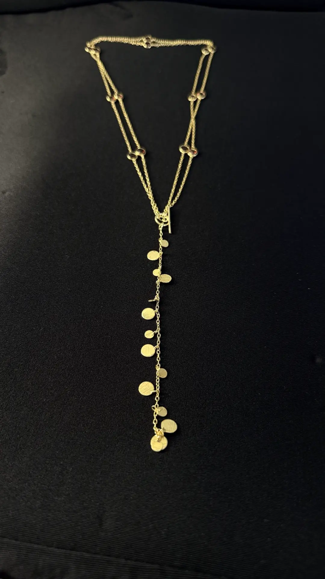 The full Payal garnet disc lariat laid out
